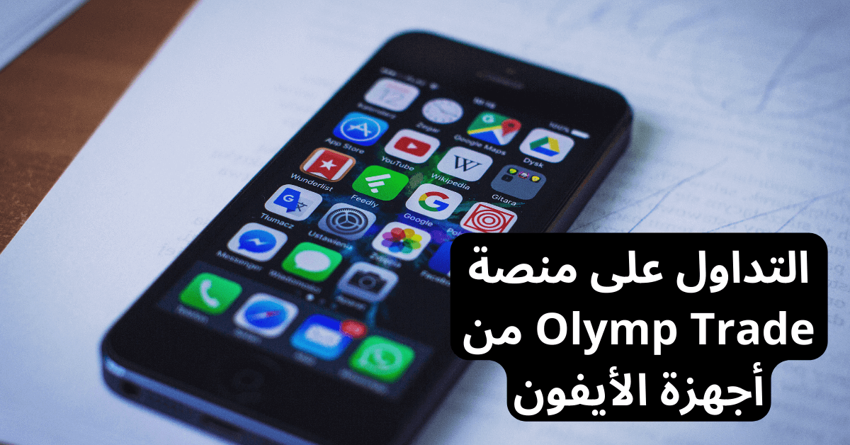 olymp trade iphone التداول على منصة أولمب تريد في الايفون جهاز أيفون فوق ورقة بيضاء موضوعة فوق طاولة خشبية